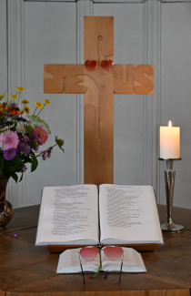 Gefühl – mit Liebe angeschaut: Altarkreuz mit ausgeschlagener Bibel und "Herz"-Brille