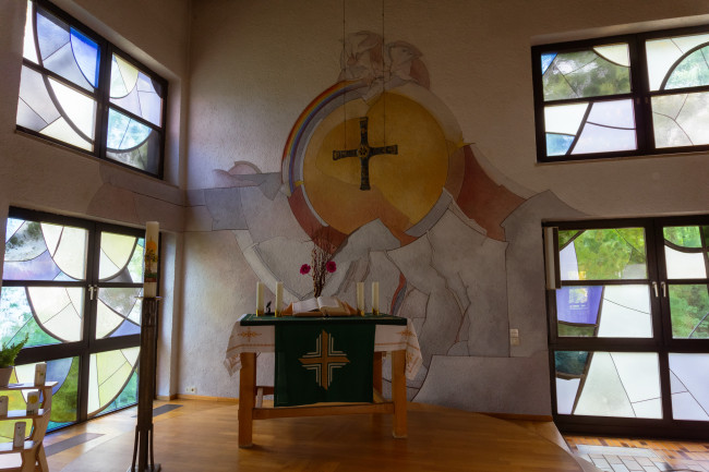 Altar mit Wandmalerei im Hintergrund
