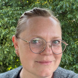 Frau mit Brille vor Grün